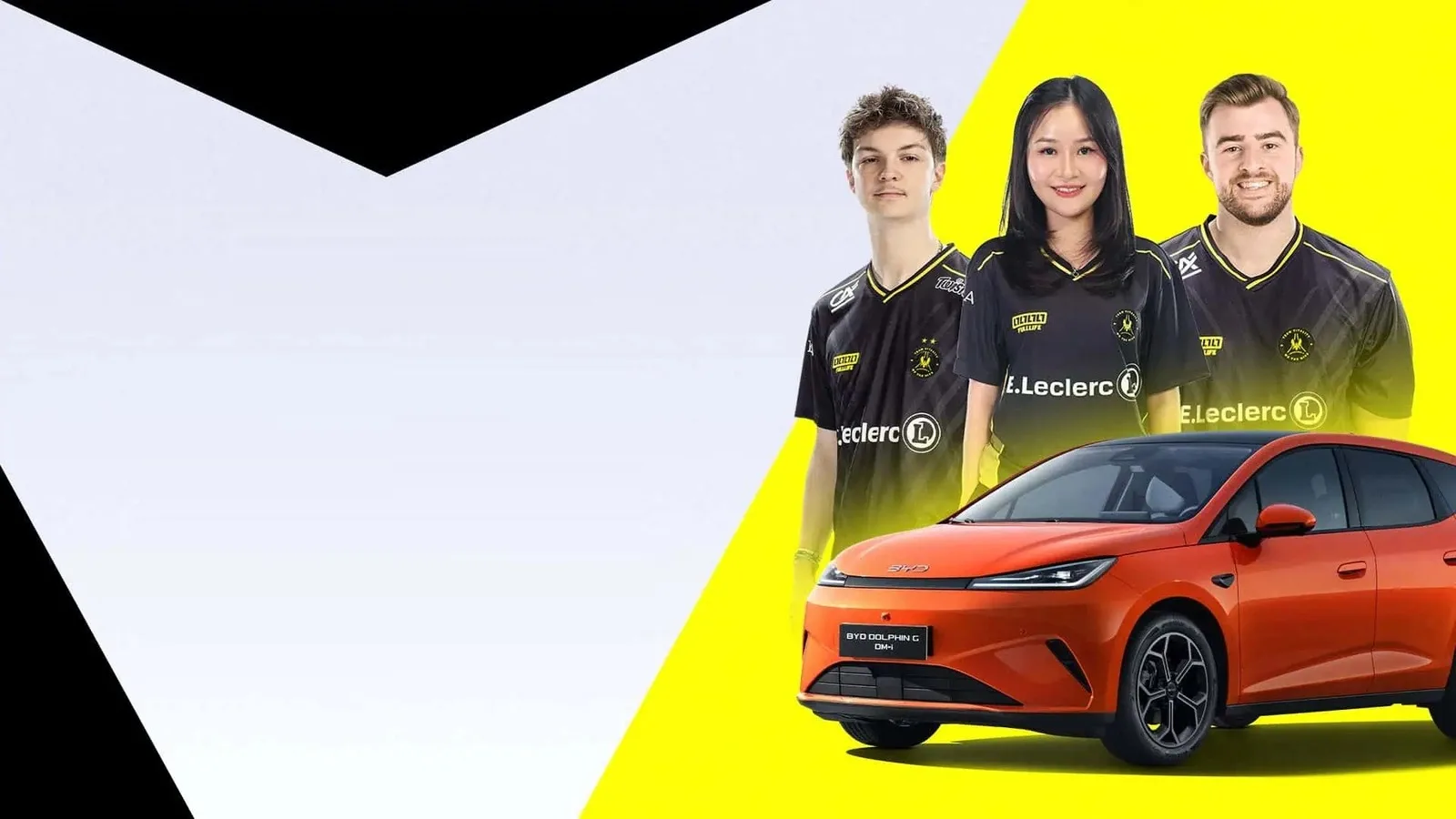 Three Team Vitality players in black and yellow club jerseys standing behind an orange BYD Dolphin G, on a yellow and white background.